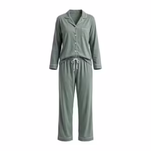 Ladies sage green two-piece pyjama set in cotton single jersey, full front view of the matched pair: a button-front top with a notched collar, white piping on the collar, placket and cuffs, matte buttons and a chest pocket, worn with long pants with an elastic waistband, a white drawcord and piped hems