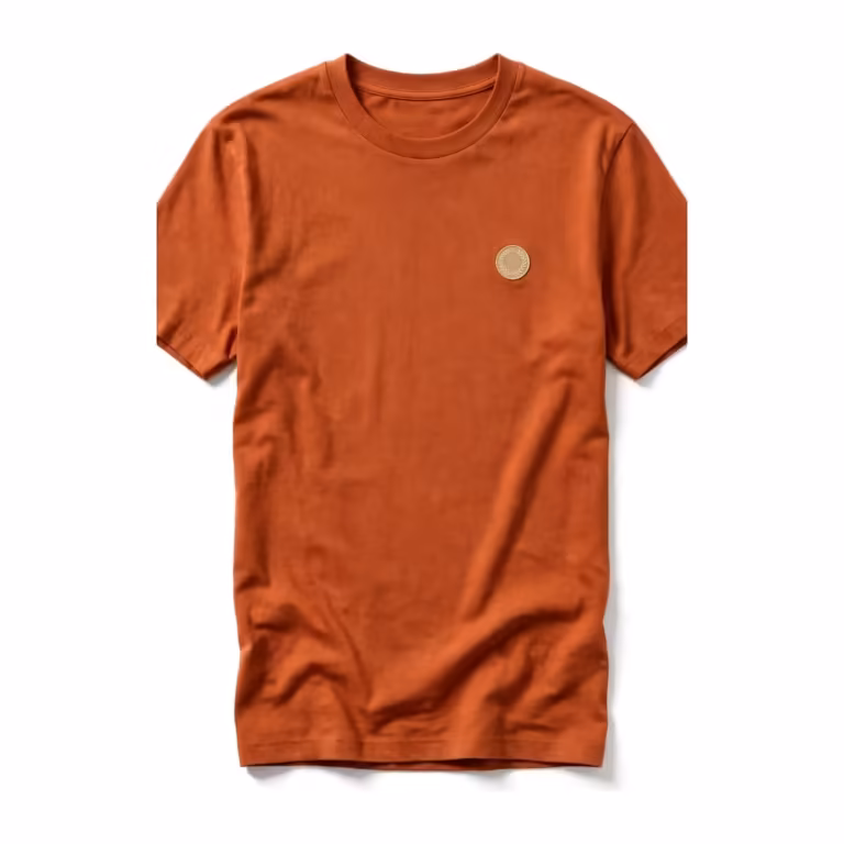 Men's custom made t-shirt in terracotta cotton jersey, full front view with ribbed crew neck and a small cream embroidered emblem on the left chest