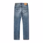 Men's denim pants in stonewash, back view with yoke, two arc-stitched patch back pockets and a plain tan leather-look patch on the waistband