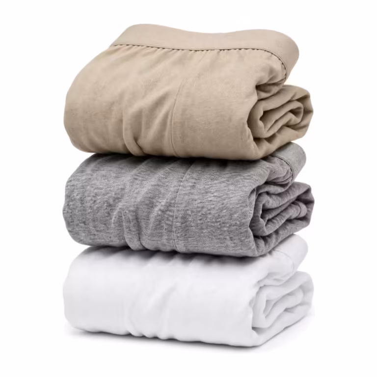 Folded multipack stack of men's cotton briefs in stone beige, grey marl and white, with soft elastic waistbands along the folded edges