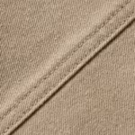 Close-up of the stone cotton twill weave and stitched seam of the jacket