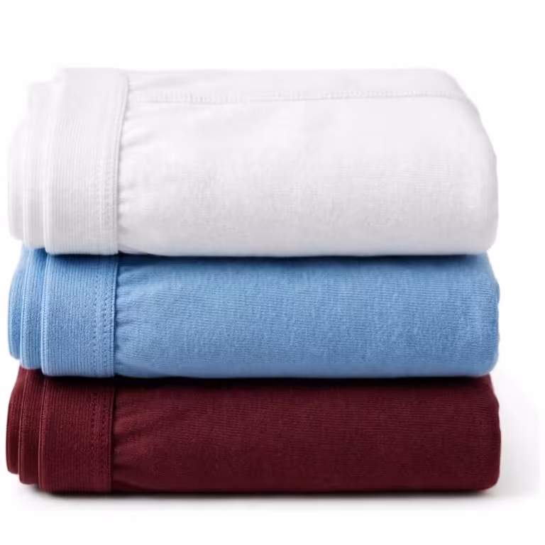 Folded multipack stack of men's knit underwear in white, sky blue and burgundy, with soft elastic waistbands along the folded edges