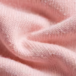 Close-up of the soft pink cotton single jersey showing the fine knit stitch loops, yarns and natural fibre texture