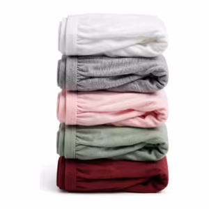 Folded multipack stack of ladies cotton panties in white, grey marl, soft pink, sage green and burgundy, the covered elastic waistband edges showing along the folds